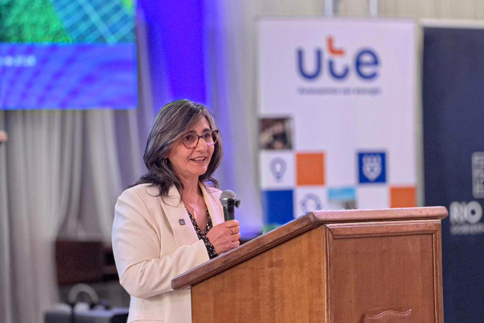 Andrea Cabrera, presidenta de UTE Cabrera habla desde un atril; detrás, banner de UTE