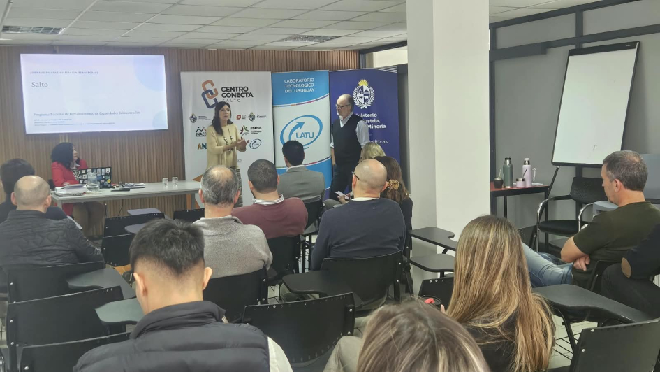 Jornada de Sensibilización en Centro Conecta Salto Papago, sentada; Schroeder habla; Pippolo, de pie; el público escucha