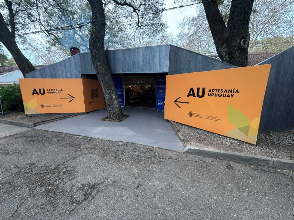 Entrada al pabellón De lejos, stand con nombre del pabellón y árboles