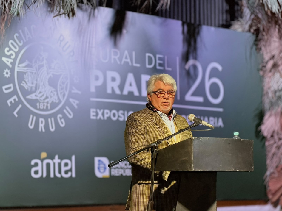Aguerre habla desde un atril; detrás, logo de la Rural del Prado