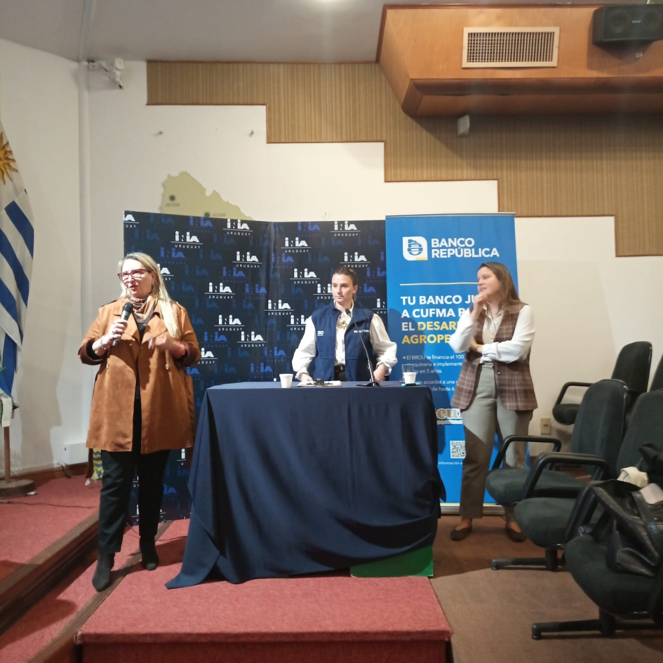 El BROU presentó sus instrumentos para productores familiares y fabricantes de maquinaria Tres mujeres, de pie; una de ellas habla con un micrófono