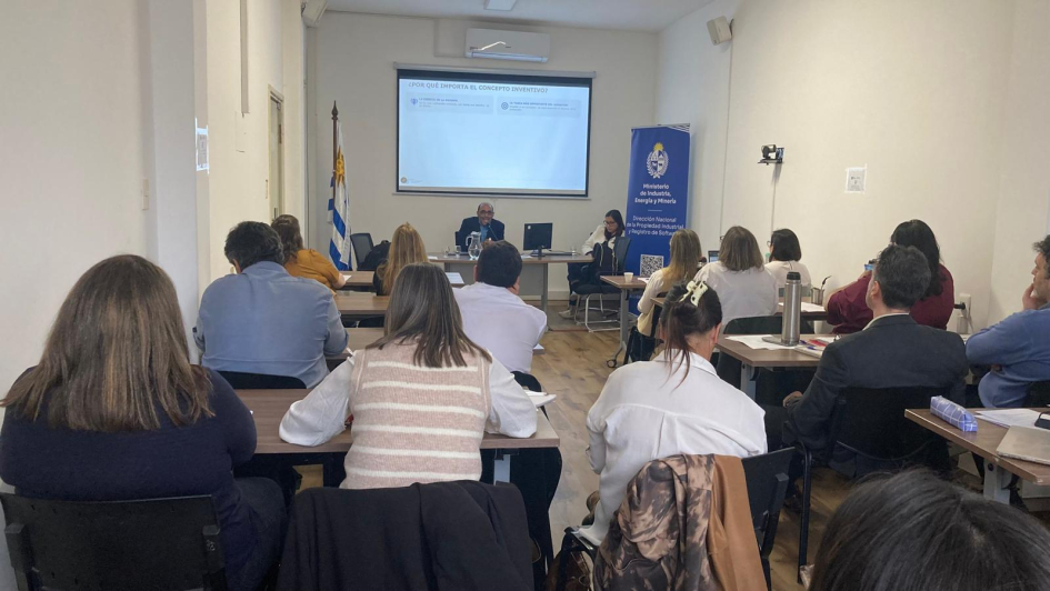Varias personas sentadas miran una pantalla.