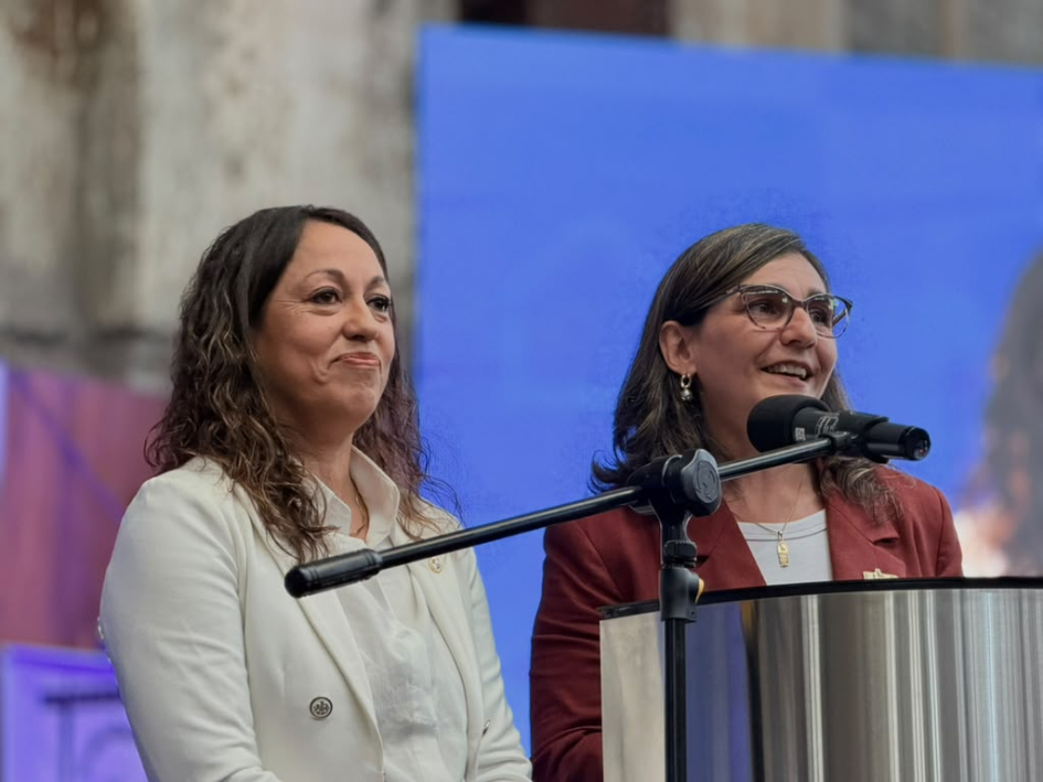 Ministra Fernanda Cardona y presidenta de UTE, Andrea Cabrera Cardona y Cabrera, de pie; la segunda habla desde un atril
