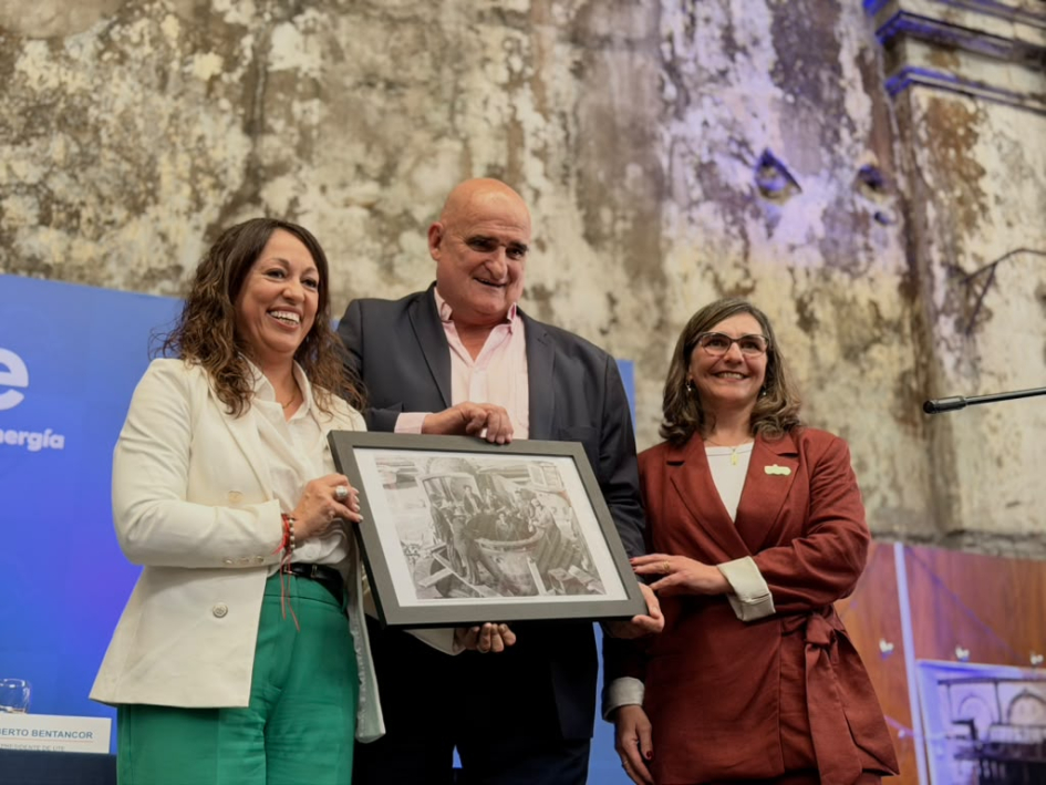 Ministra Fernanda Cardona; vicepresidente de UTE, Roberto Bentancor; y presidenta, Andrea Cabrera Cardona, Bentancor y Cabrera sostienen un cuadro