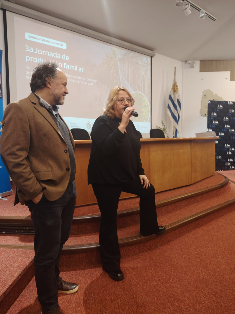 La directora de la Dinapyme, Ximena Cidrás, explicó el alcance del acuerdo con la CUMFA Cidrás habla, de pie, junto a un hombre; detrás, mesa y pantalla
