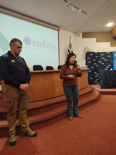 Presentación de la CUFMA, que anunció un acuerdo con INIA Las Brujas Una mujer y un hombre, de pie; detrás, mesa y pantalla