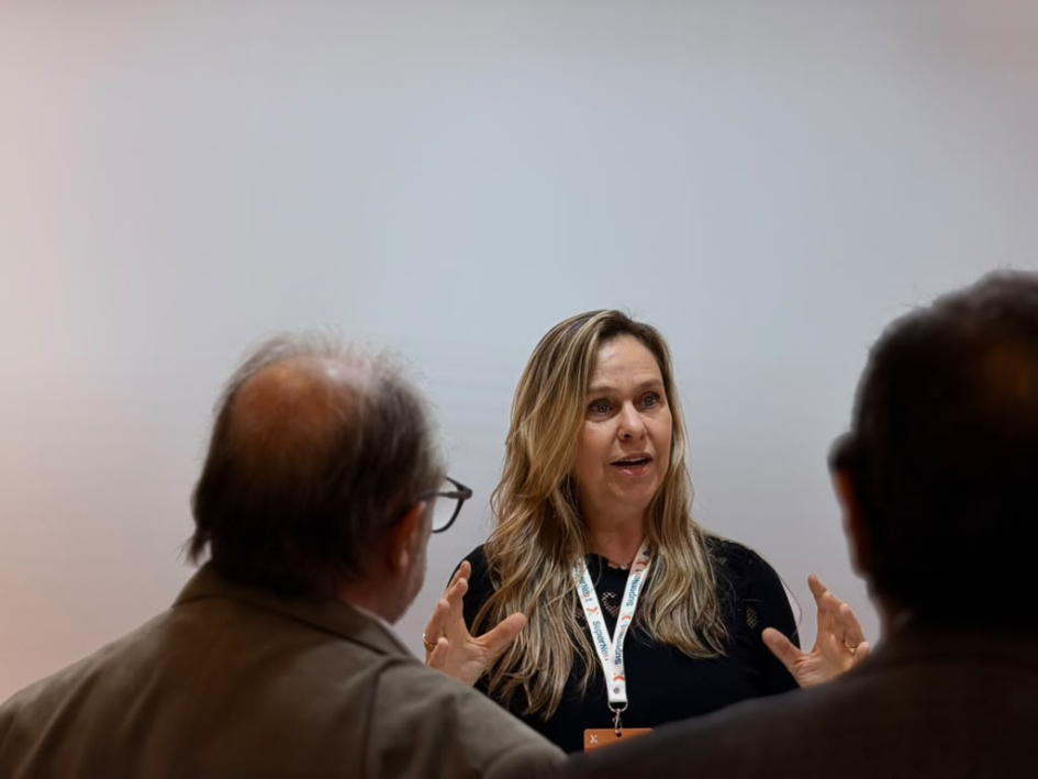 Mujer, representante de las mipymes, dialoga con Olesker y otra persona, que están de espaldas