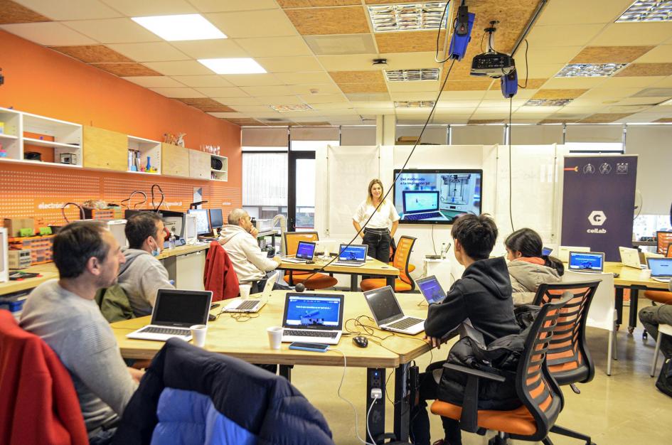 Las autoridades de Microsoft visitaron el Salón Ceibal Varias personas están reunidas en mesas en un salón