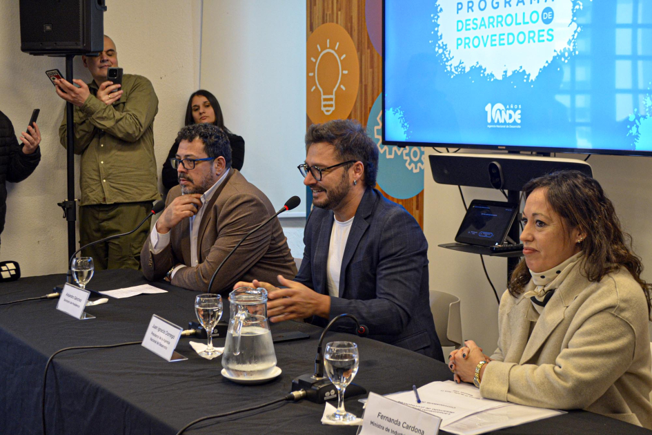 Mesa de autoridades con Sánchez, Dorrego y Cardona; detrás, pantalla