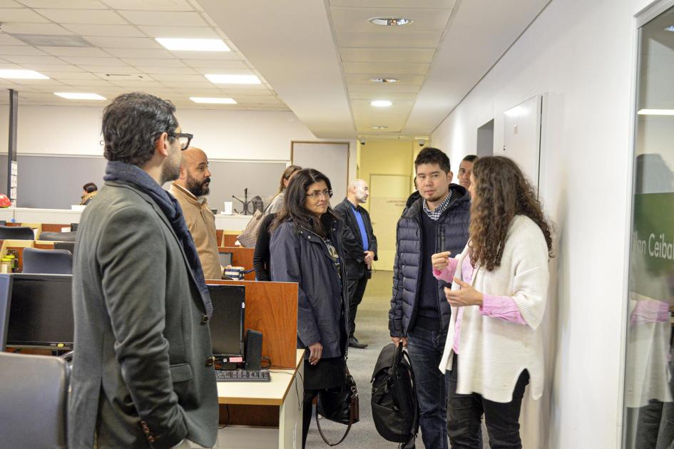 Las oficinas de Ceibal recibieron a las autoridades de Microsoft Varias personas están de pie en una oficina, dialogando