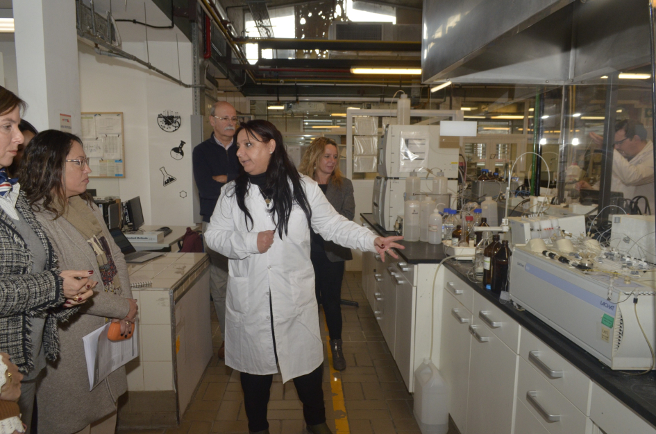 Recorrida por los laboratorios del LATU Ministra Cardona dialoga con una mujer de túnica, junto a otras personas
