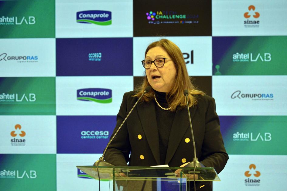 Presidenta de Antel, Annabela Suburú Presidenta de Antel habla con un micrófono; detrás, banner