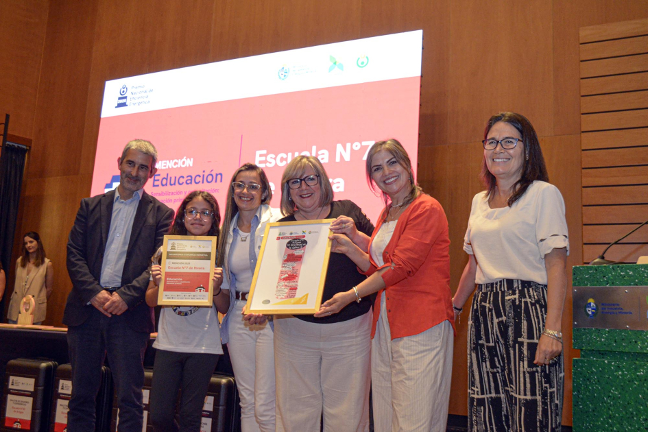 Niña, docentes y autoridades, en entrega de premio