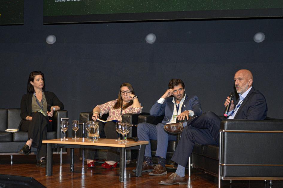 Panel en el que intervino la coordinadora del programa de hidrógeno del MIEM, María José González Panel en el que se ven cuatro personas; un hombre sostiene un micrófono; están sentados