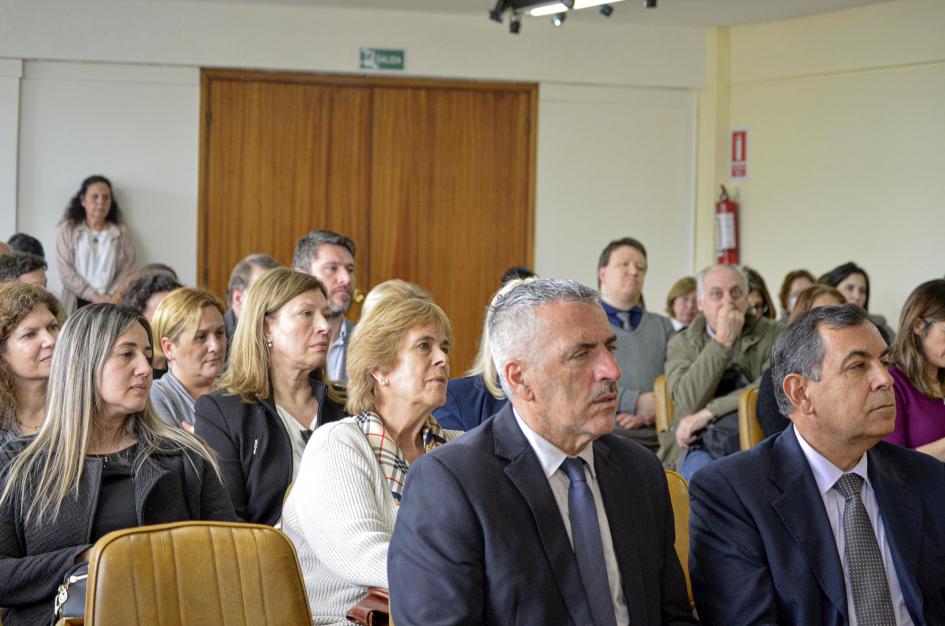 Entre el público había funcionarios y autoridades del MIEM y otros organismos Público y autoridades, sentadas en la sala; al fondo hay una puerta de madera cerrada