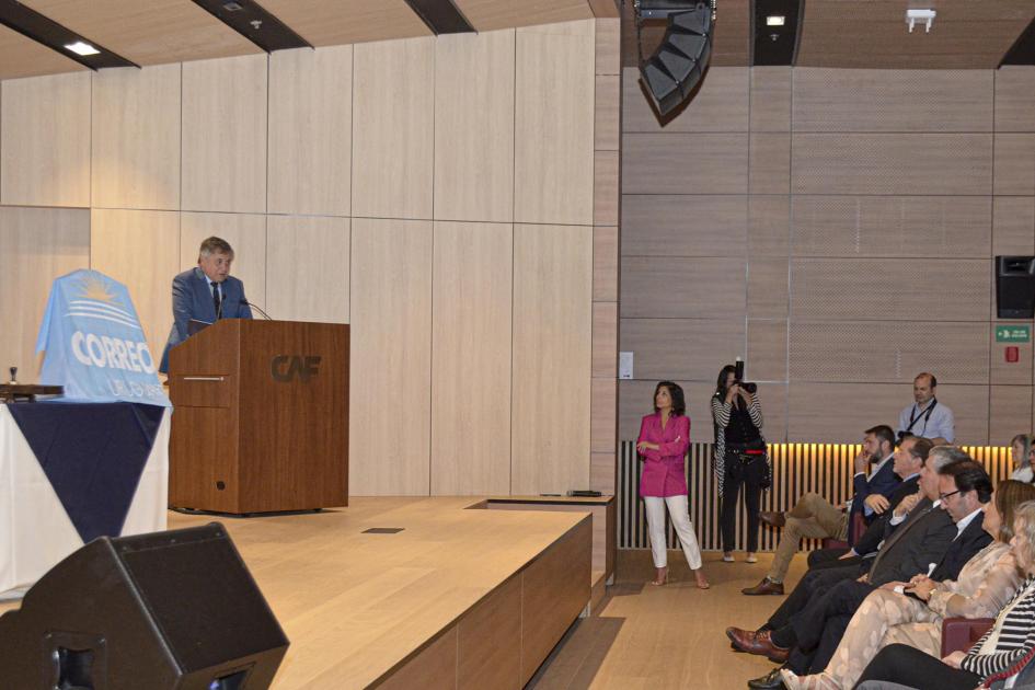 La actividad se desarrolló en el anfiteatro de la sede de la CAF Ministro Paganini habla desde un atril; frente a él, el público