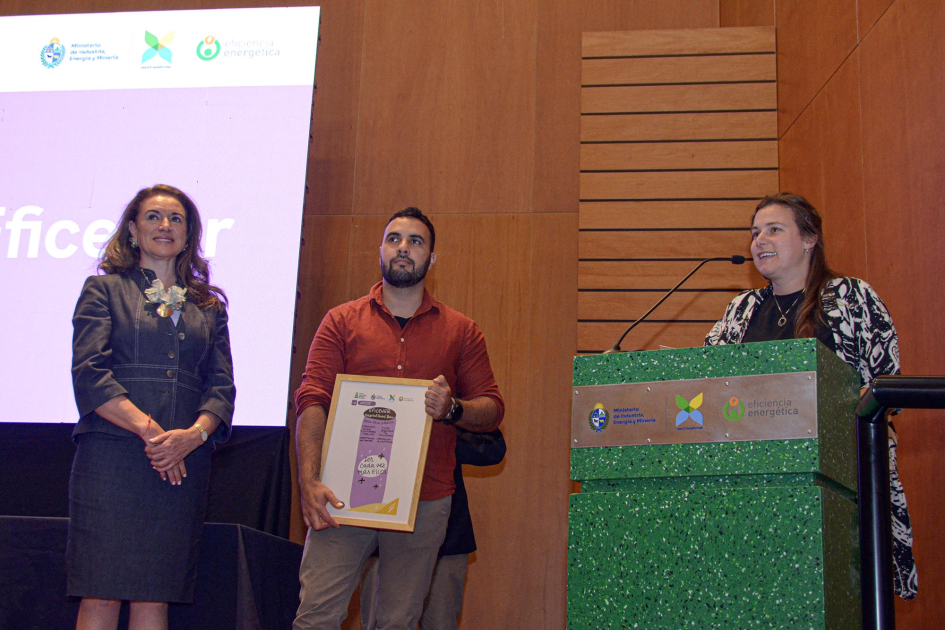 Representante de la ESCO habla en atril, mientras otro recibe el premio