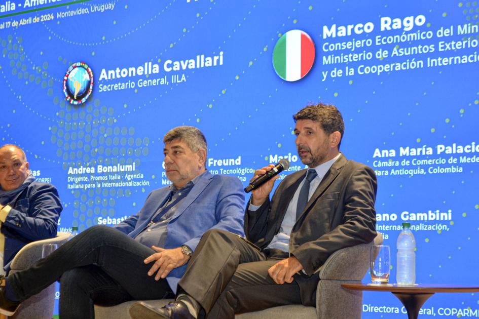 Sebastián Pérez, representante de la CIU Pérez habla sentado en un sillón; a su lado, dos hombres; detrás, una gran pantalla