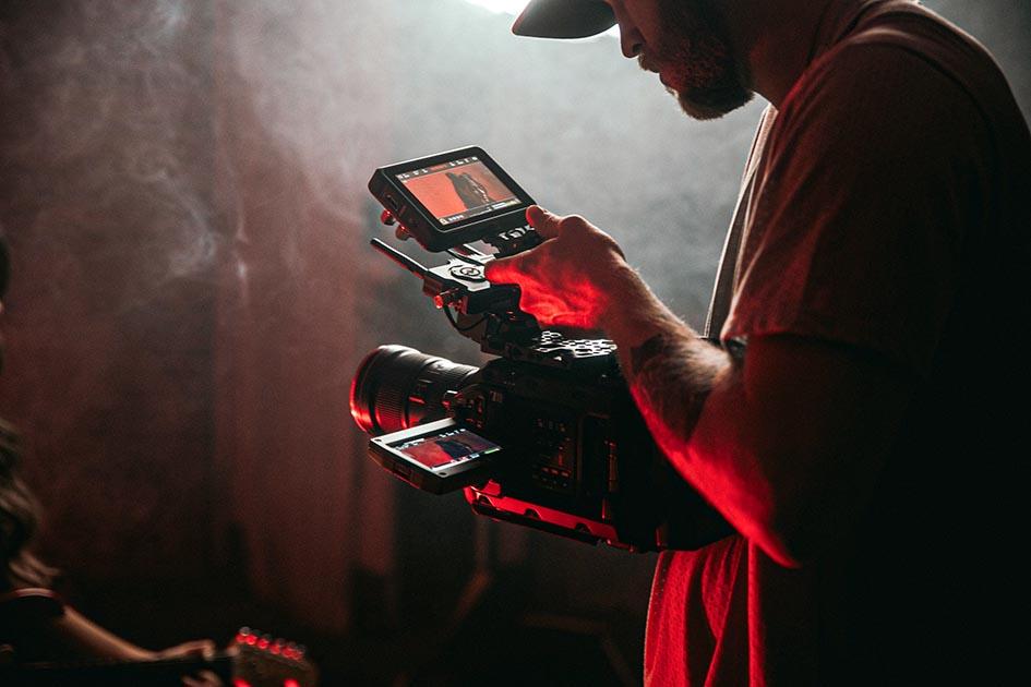 foto audiovisual camarógrafo revisando en su cámara grabación hecha