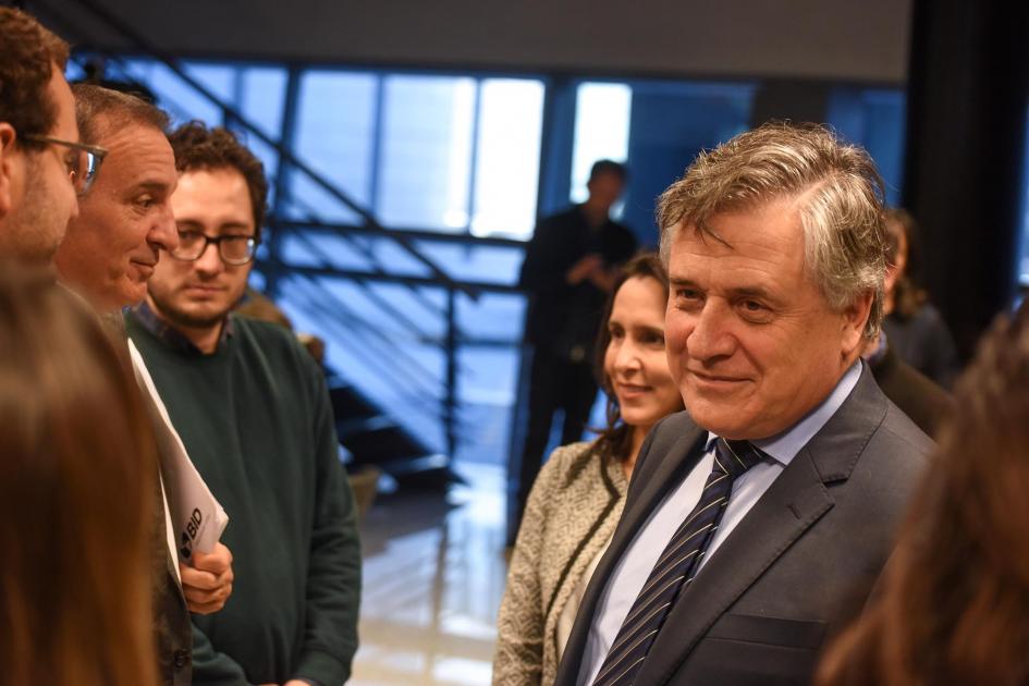 Diálogo entre las autoridades Paganini sonríe mientras dialoga con las autoridades