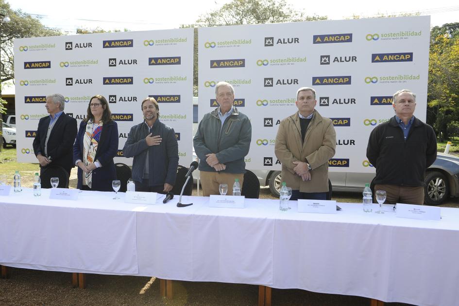 Mesa de autoridades Autoridades, de pie, detrás de una mesa; al fondo, banner de ALUR