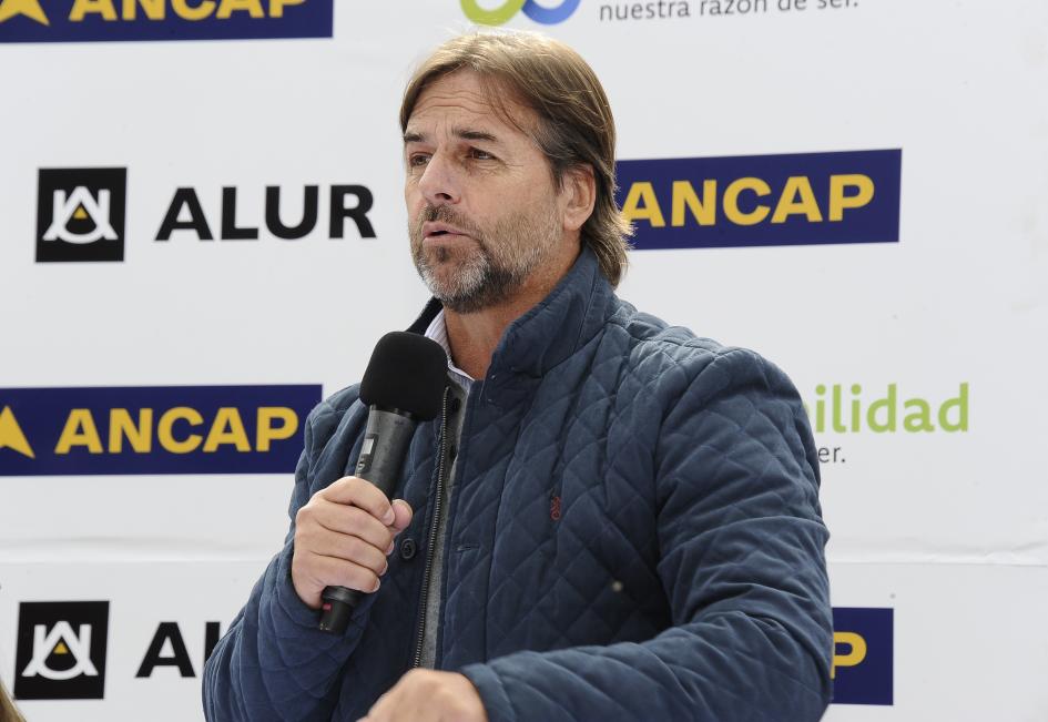 Presidente Luis Lacalle Pou Presidente Luis Lacalle Pou habla con un micrófono, detrás, banner de ALUR