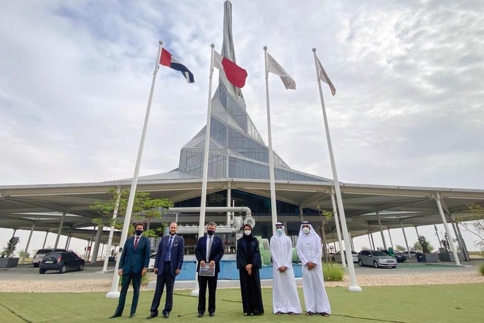 El ministro Omar Paganini junto a autoridades de EAU; detrás se ven un moderno edificio y banderas