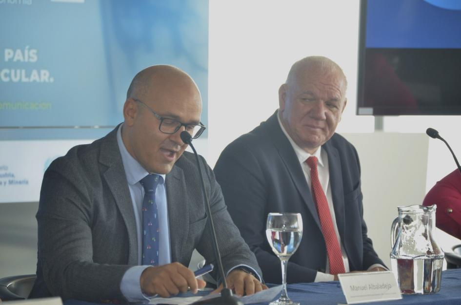 Manuel Albaladejo, junto a Walter Verri Albaladejo habla junto a Verri; detrás, dos pantallas con el logo