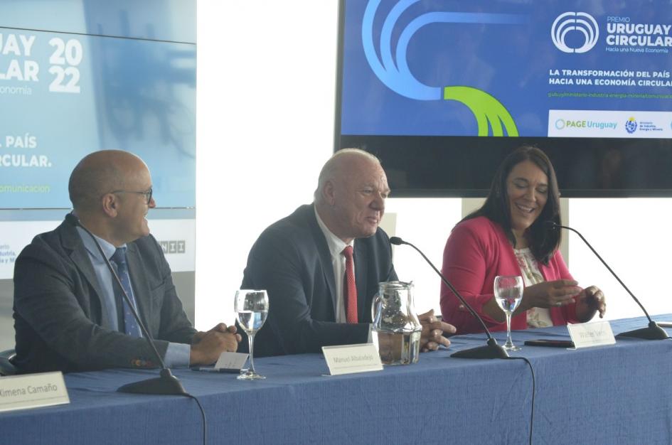 El ministro interino Walter Verri expuso en la apertura Mesa de autoridades; habla Verri junto a Sánchez y Albaladejo; hay dos pantallas con el logo