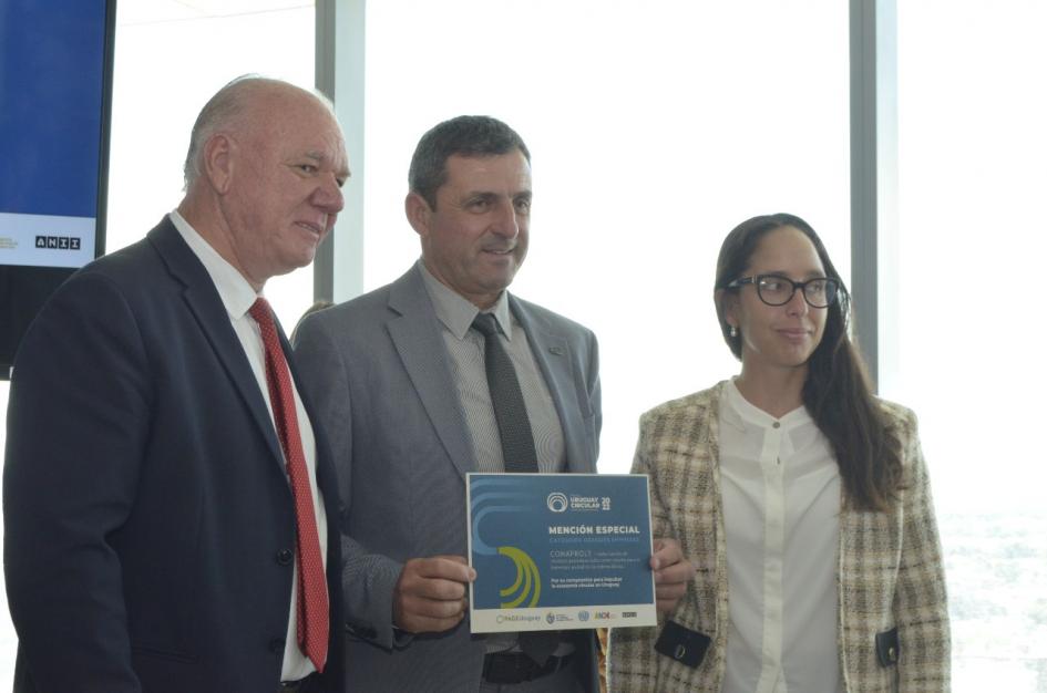 Mención en categoría Grandes empresas: Conaprole Un hombre sostiene un diploma; a su lado Verri y una mujer