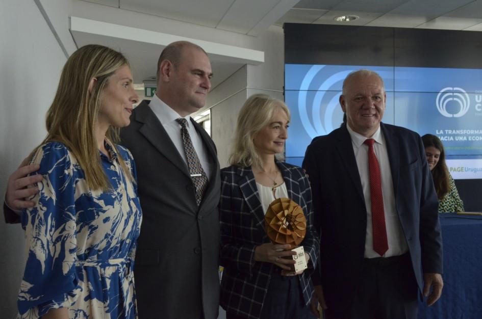 Premio en categoría Grandes empresas: Montes del Plata Verri, dos mujeres (una, con el premio en la mano) y un hombre; detrás, pantalla con el logo