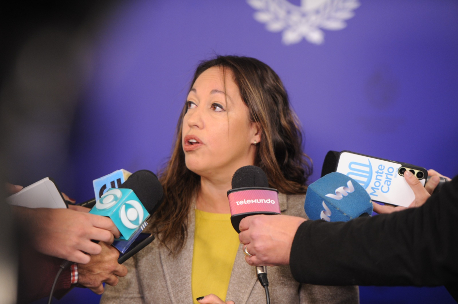 Rueda de prensa del 30 de junio (foto de Presidencia de la República) Ministra habla, rodeada de manos de periodistas con micrófonos