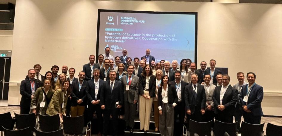 Delegación uruguaya en Países Bajos, que incluyó autoridades y a más de 35 empresarios Muy numerosa cantidad de personas posan de pie; arriba, una pantalla