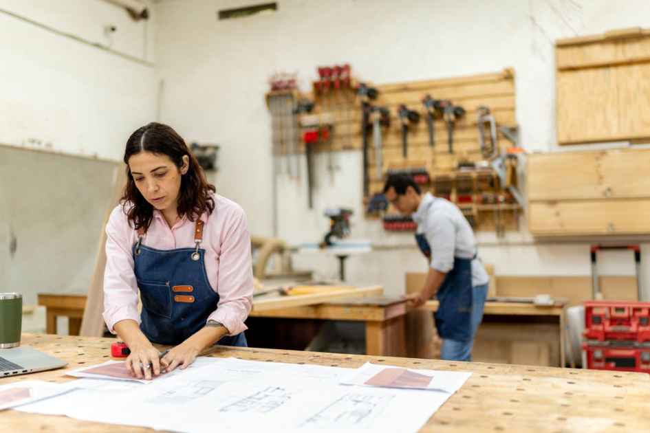 Mujer y hombre, con delantales, trabajan en un taller