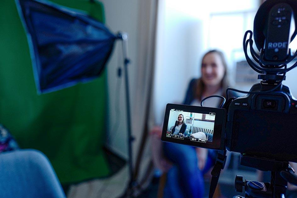 El cortometraje debe representar la actividad de las mujeres en la actividad productiva El visor de una cámara muestra a una mujer que también aparece, fuera de foco, detrás del visor