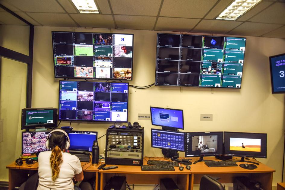 Laboratorio Digital del MIEM Mujer, de espaldas, trabaja en un laboratorio con distintas pantallas