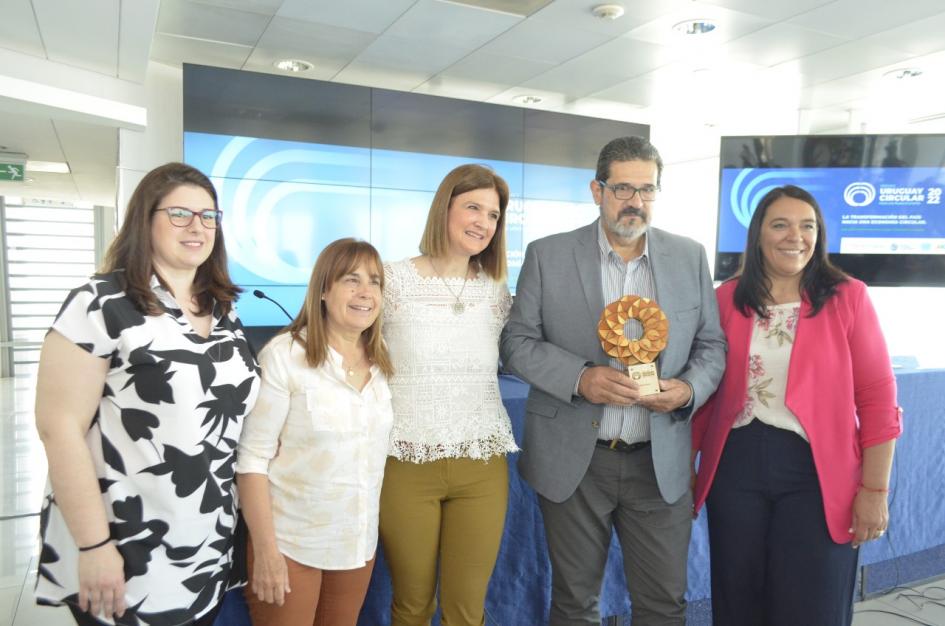 Premio en categoría Mipymes: Plamet Sánchez sonríe junto a tres mujeres y un hombre, que sostiene el premio (una creación sustentable)