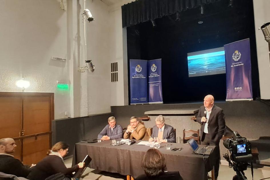 Subsecretario Walter Verri habló junto al resto de las autoridades Verri habla de pie, en la mesa de autoridades; detrás se ve un escenario con una pantalla y banners