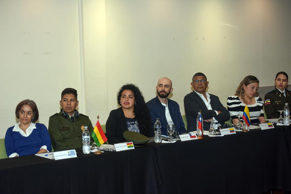 Participantes en sala Participantes sentados en una mesa