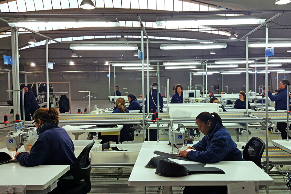 Datos del IVF industrial de abril Mujeres cosen en mesas, en una planta industrial