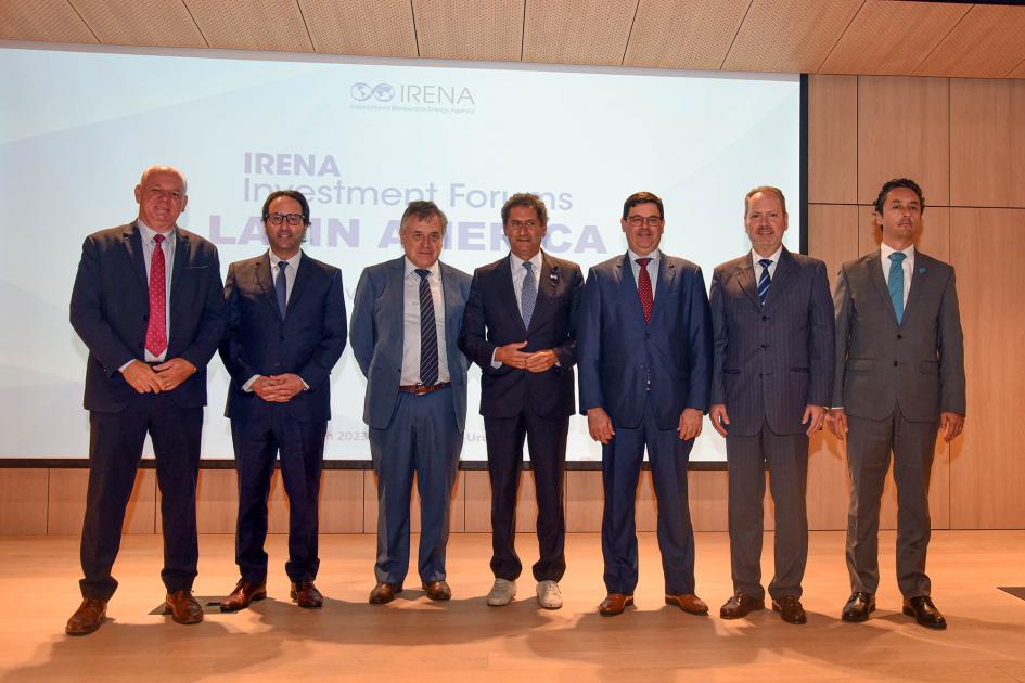 Foto grupal en la sede de CAF Autoridades y La Camera en la CAF; detrás, una pantalla