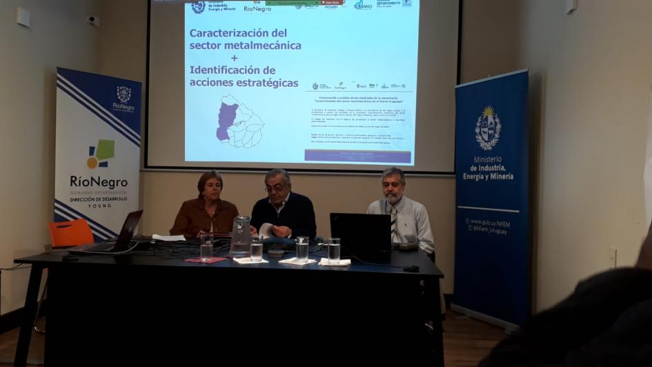 Apertura de la actividad Autoridades en una mesa; detrás hay una pantalla y, en los costados, banne3rs