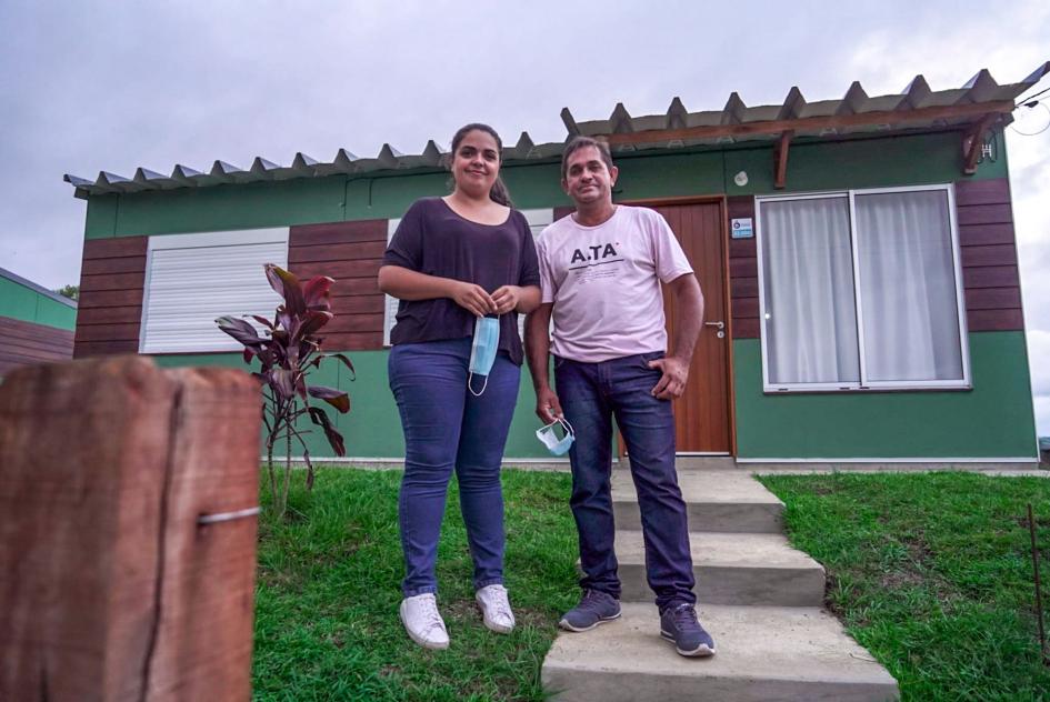 Dos usuarios muestran su nueva vivienda (crédito de la fotografía: Mevir) Dos usuarios, un hombre y una mujer, sonríen frente a una vivienda