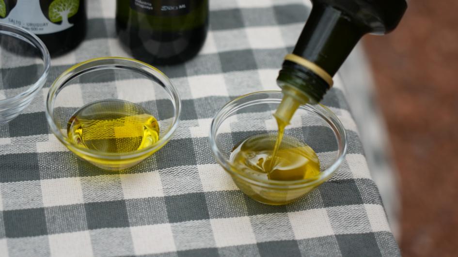 Aceite de oliva Botella de aceite sirviendo en un recipiente. Al lado hay otro recipiente con aceite