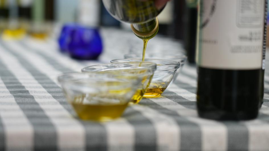 Aceite de oliva Mesa con dos recipientes con aceite. Se ve media botella.