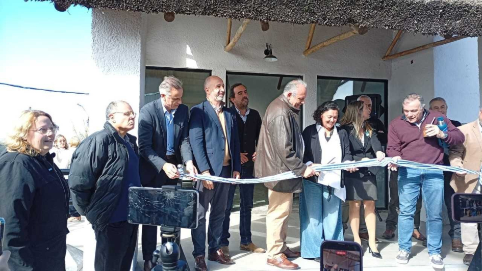 Personas cortan una cinta frente a la sede de la Casa de Turismo