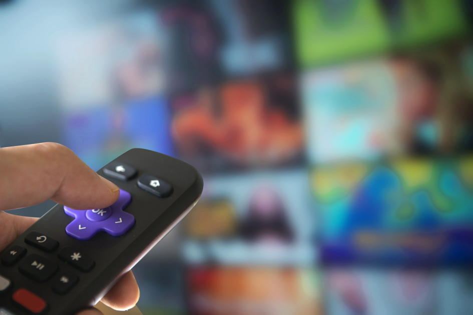 Uruguay completa la transición a la televisión digital el 25 de setiembre a las 23.59 horas Mano toma control remoto; fuera de foco, pantalla de TV