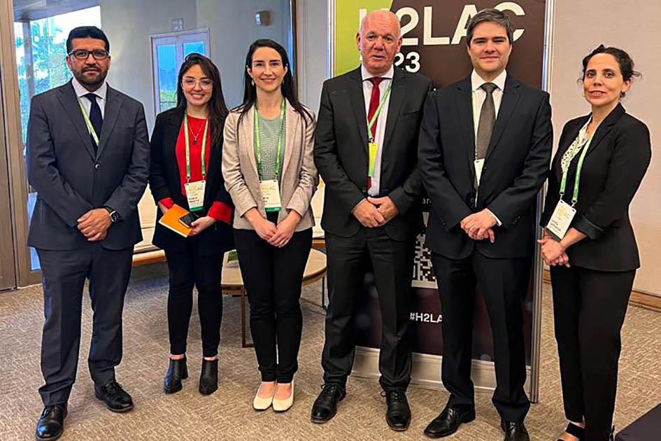 Verri se reunió con el viceministro de Energía chileno, Luis Felipe Ramos Verri posa, de pie, junto a tres mujeres y dos hombres; detrás hay un banner del evento
