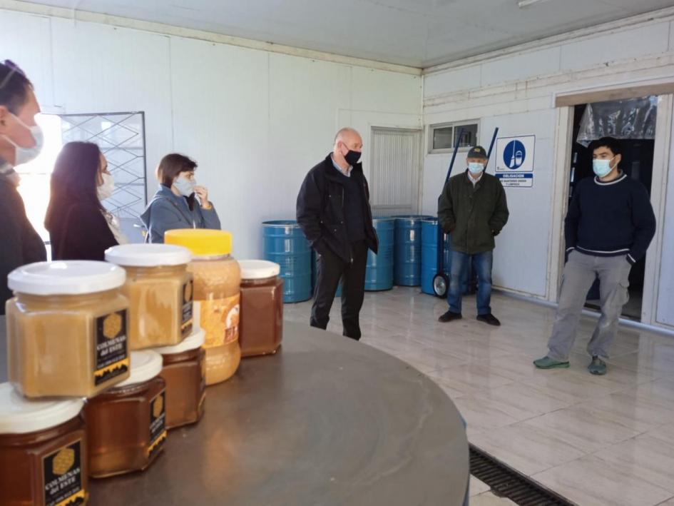 Diálogo con el subsecretario Walter Verri Se ven potes de miel, el subsecretario Verri y otras personas