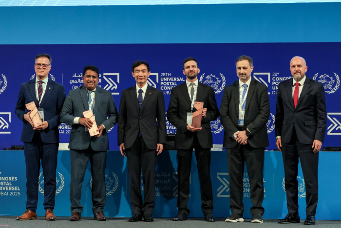 Director Siris sostiene el premio junto a otros cinco hombres